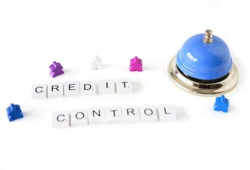 The words credit control written in wooden tiles next to a bell.