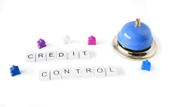 The words credit control written in wooden tiles next to a bell.